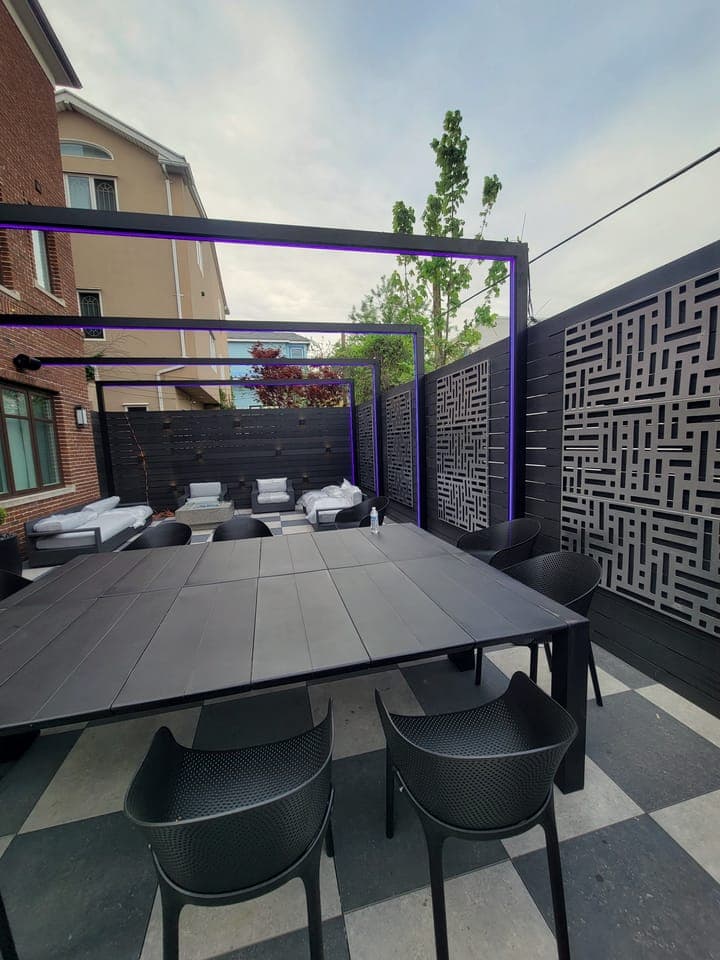 Checkerboard Patio Garden — Pergola dining with blue lighting