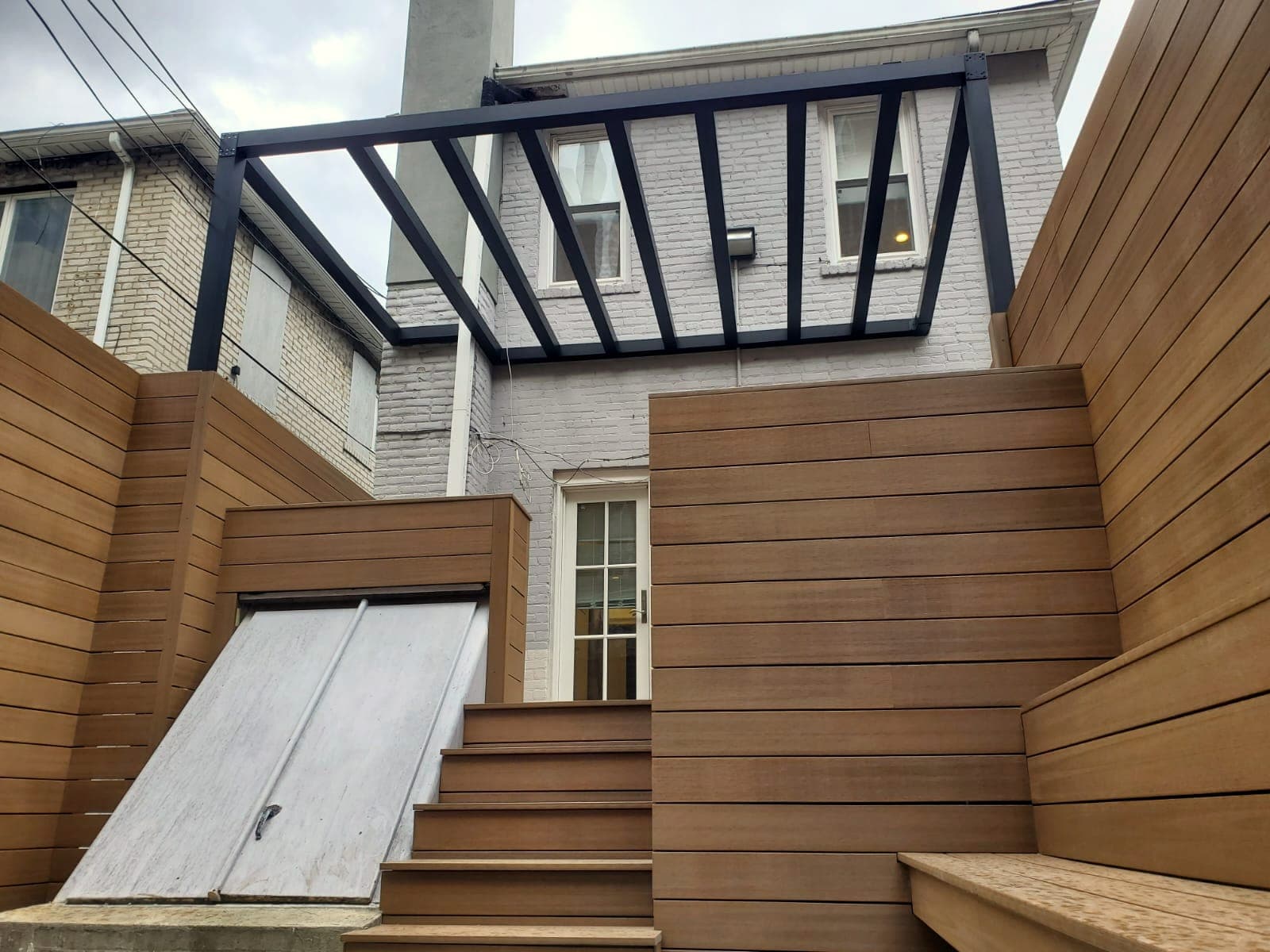 Wood-Clad Backyard Retreat — after: Clad walls, pergola, finished steps