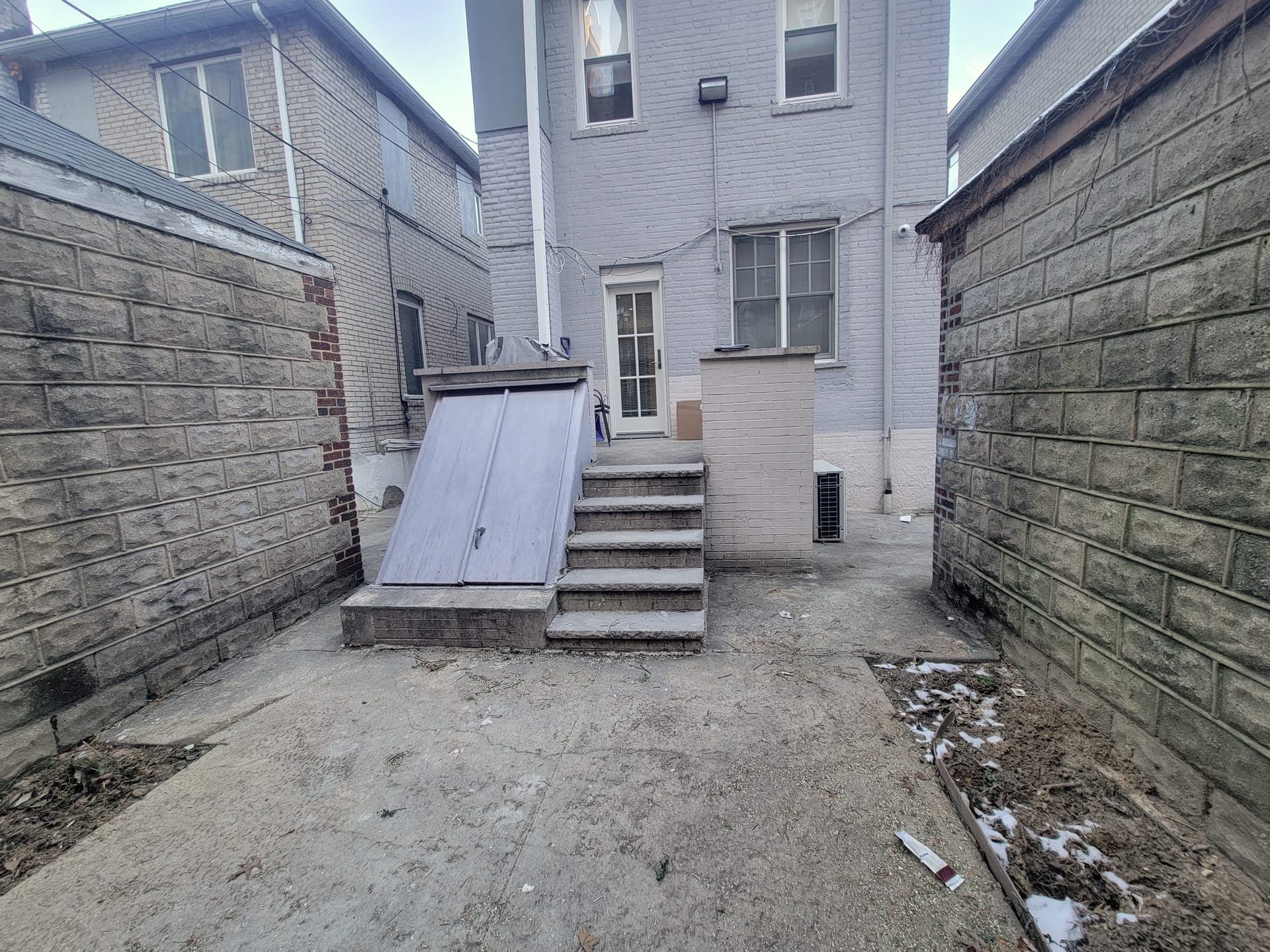 Wood-Clad Backyard Retreat — before: Empty yard facing the house
