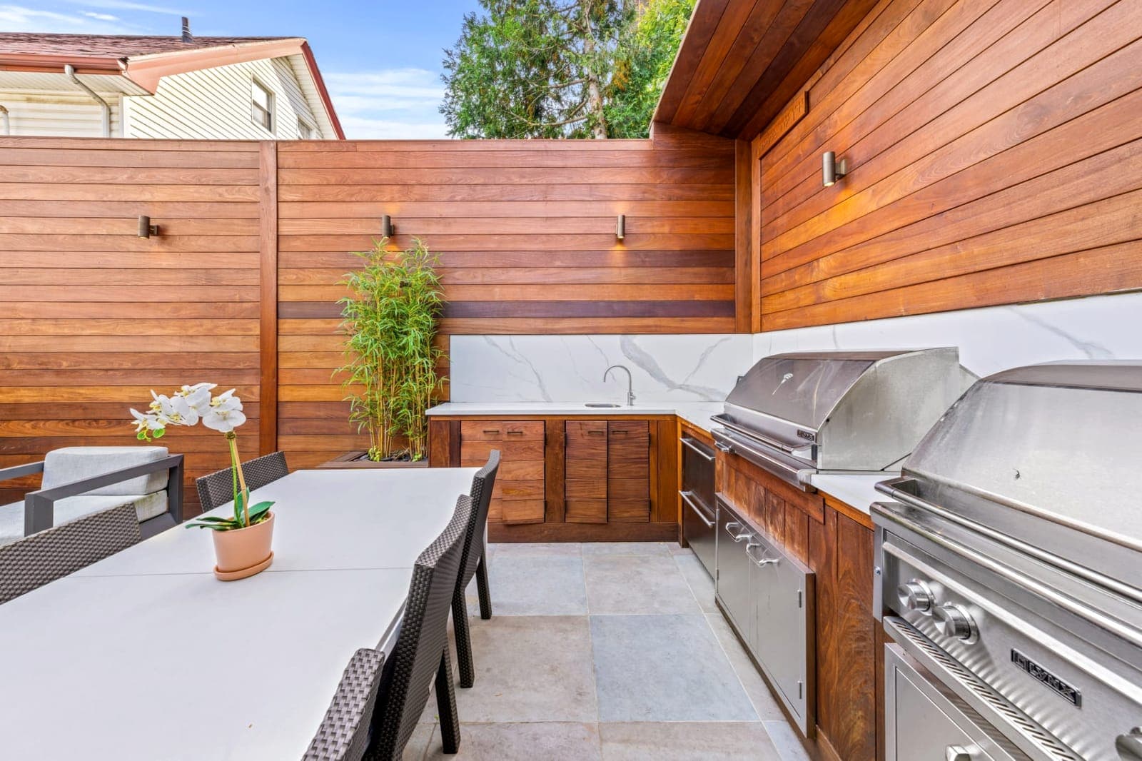 Outdoor kitchen detail showing IPE wood wall and stone counter